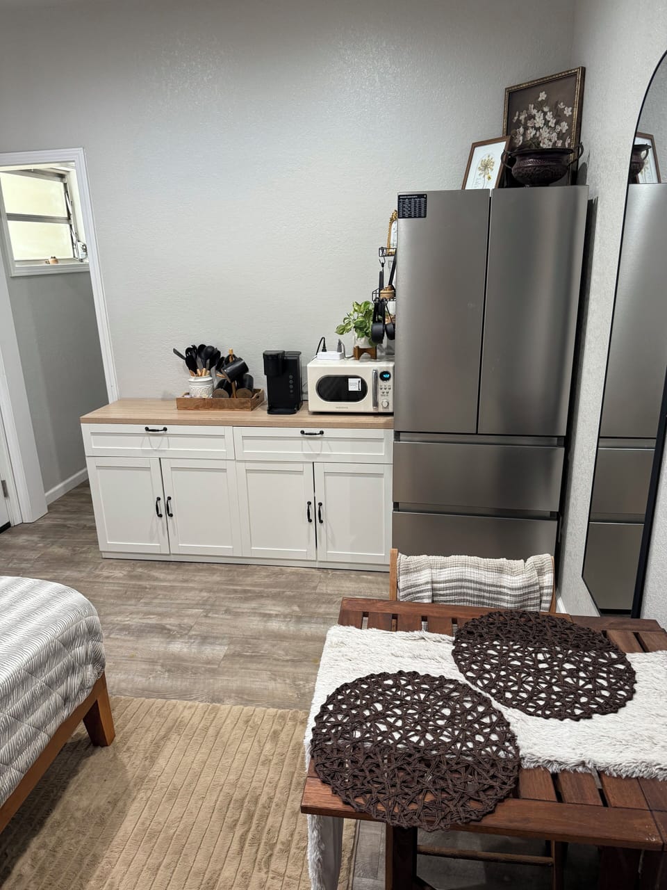 Kitchenette with microwave, air fryer, utensils, plates, and 2 burner cooktop.