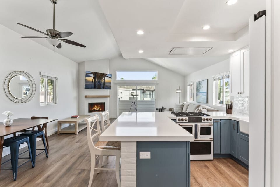 Modern kitchen w/ island seating, sleek appliances & open flow into the living space