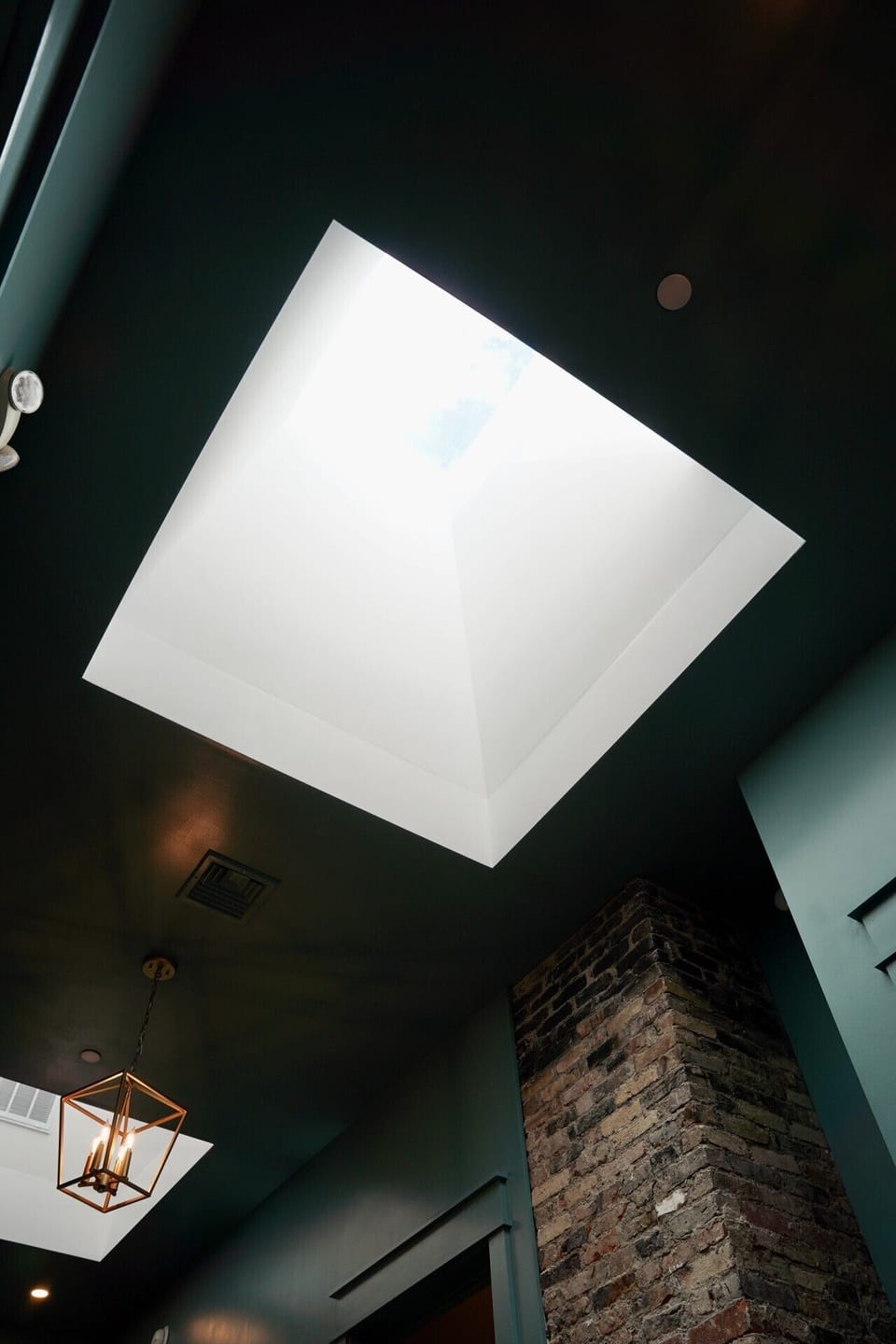 Turn of the century original brick chimney meets dramatic ceiling height. One of many architectural gems at Parkway House. This beautifully preserved Victorian detail adds character and history to every corner of the home throughout.