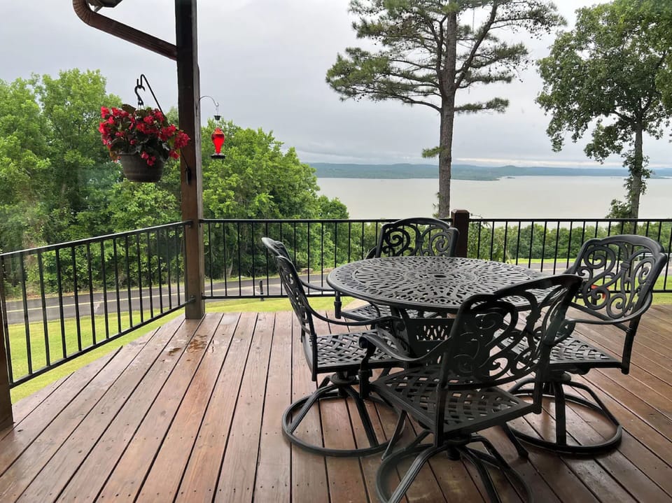 Deck that overlooks Lake Tenkiller with outdoor dining table and seating. 