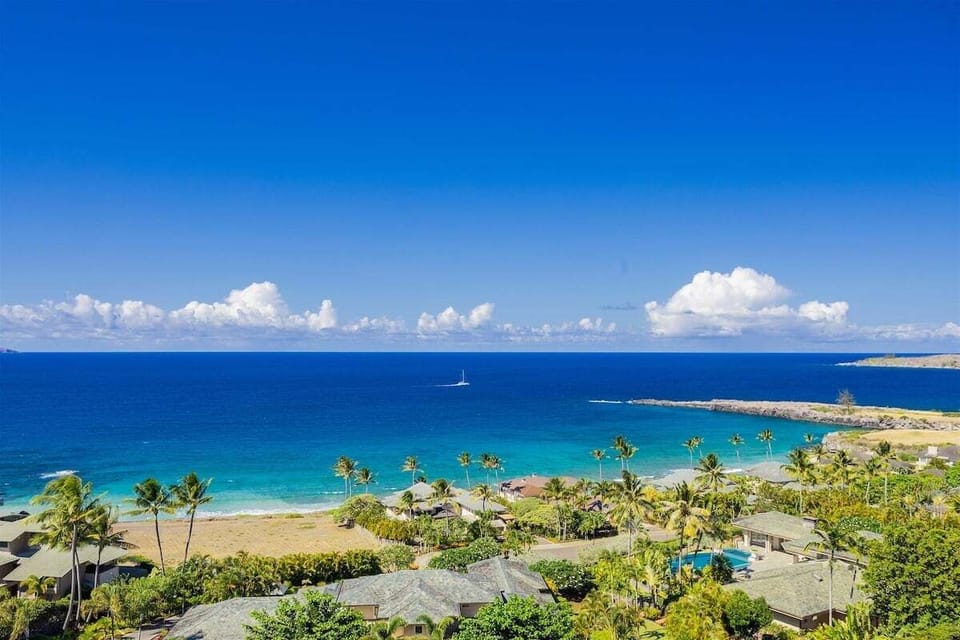 The large wrap-around windows frame sweeping views of the ocean and coastline, reaching all the way to world-famous Honolua Bay