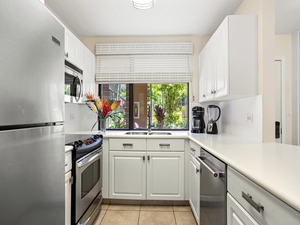 Step into your bright, beautifully organized kitchen, where sleek white cabinetry meets modern stainless appliances. Natural light filters through the window, framing vibrant greenery outside—making every meal feel fresh and inspiring.