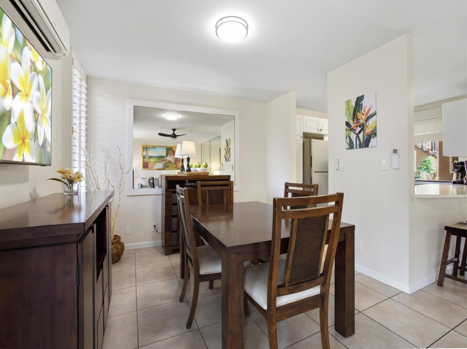 Gather around this inviting dining table where your group can share meals and make memories together in a bright, tropical-inspired space.