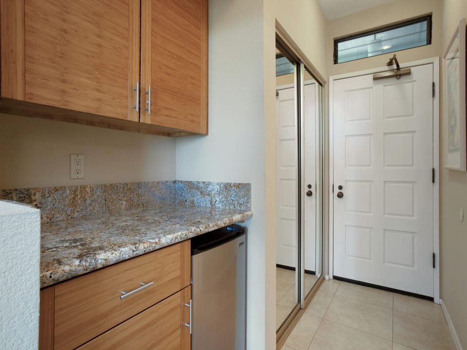 Step inside and feel instantly at home in this welcoming entryway. The granite-topped workspace and warm wood cabinetry create a functional yet inviting transition space for your arrival.