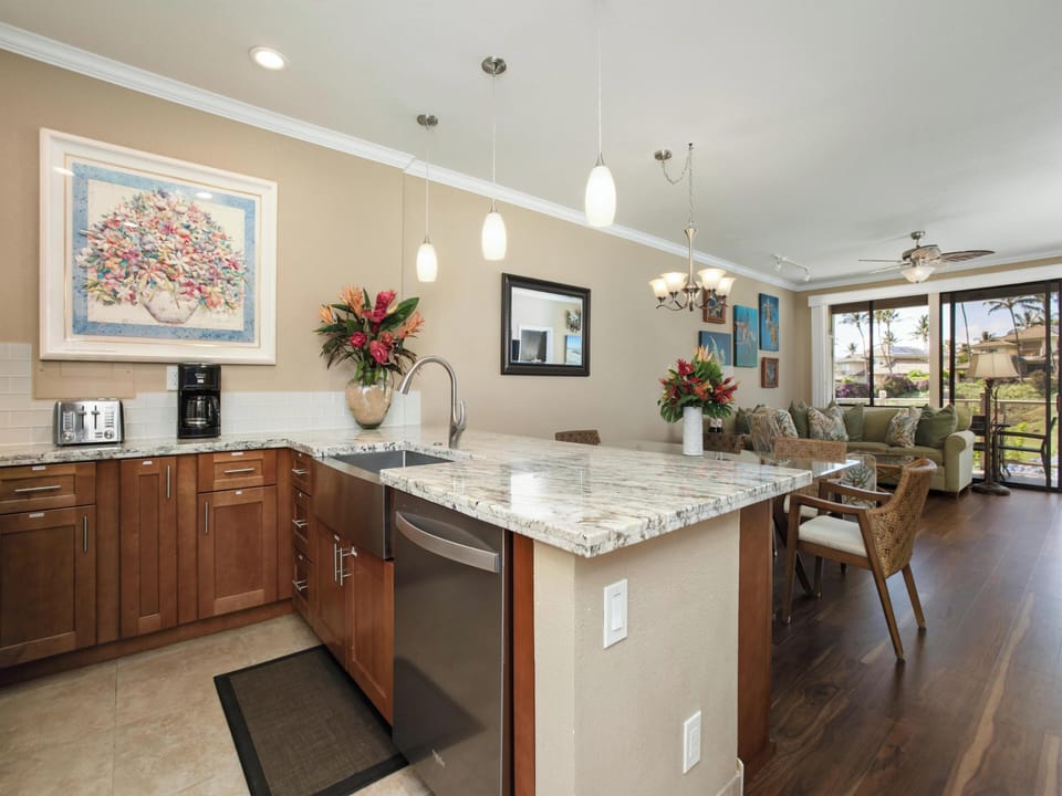 Step into your open-concept kitchen and living space with sleek granite countertops and elegant island seating. Through the windows, tropical greens and ocean blues set the scene for your island getaway.