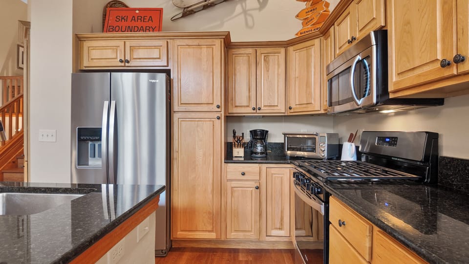 Cozy rustic kitchen with wood cabinets, stainless steel appliances 