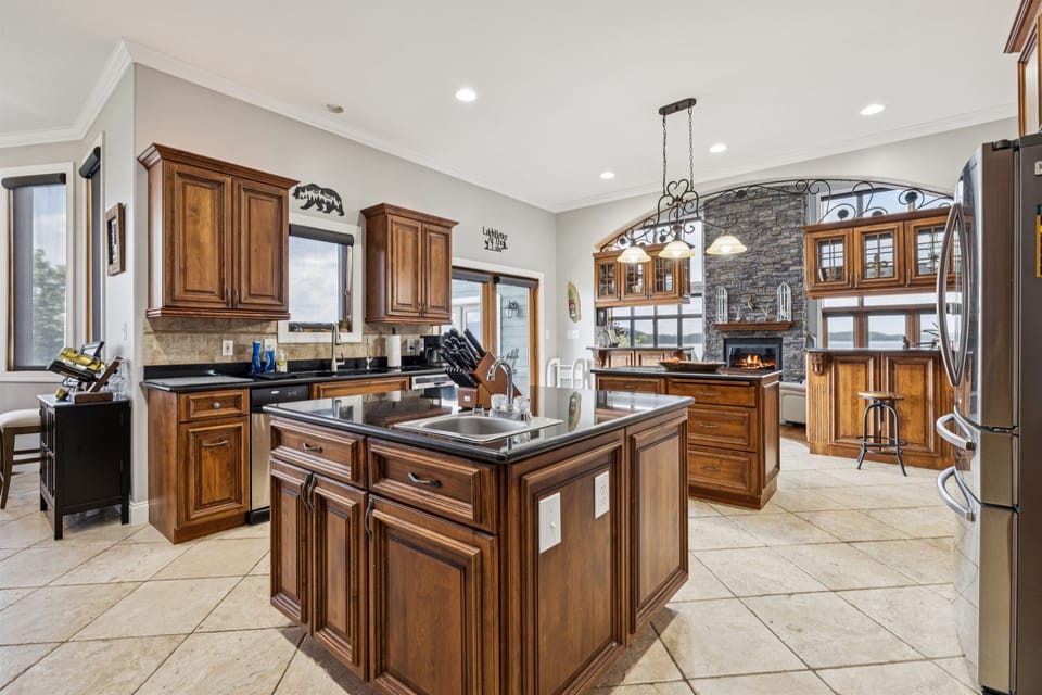Large Kitchen with 2 sinks, 2 refrigerators/freezers, multiple islands, eating area, fireplace, and large butler pantry