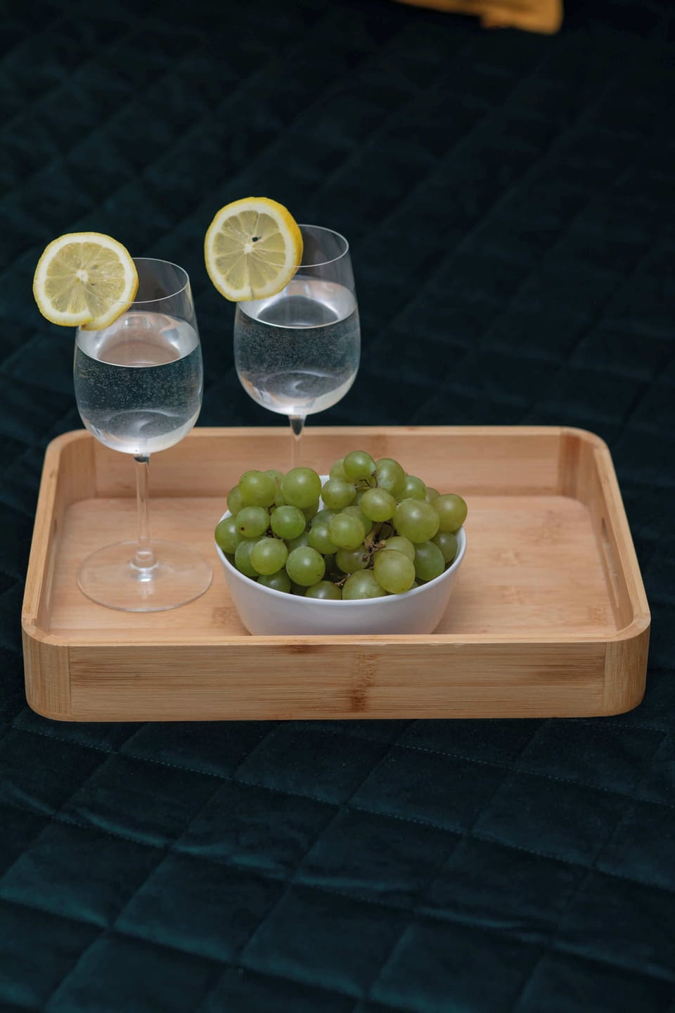 A tray with glasses of white wine and grapes. A detail evoking a sense of leisure and comfort.
