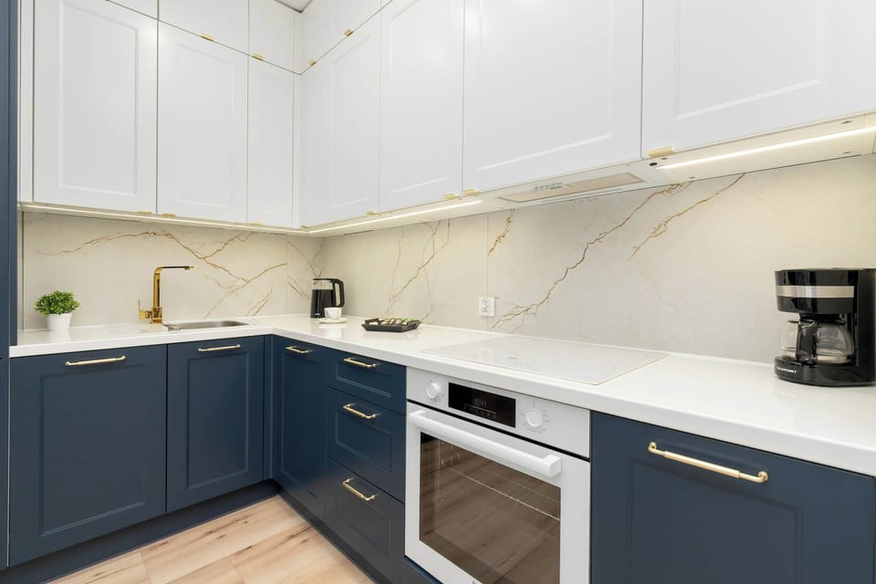 Stylish kitchen with deep blue cabinetry, white quartz countertops, and integrated modern appliances.