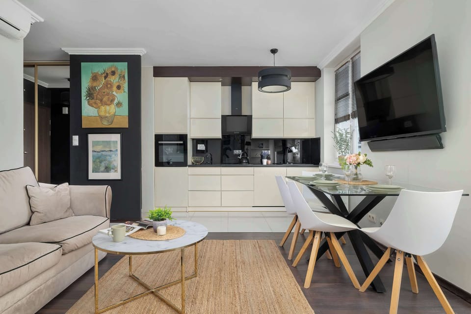 The living room with a TV and artwork on the wall blends modern style with artistic touches, creating an elegant atmosphere.