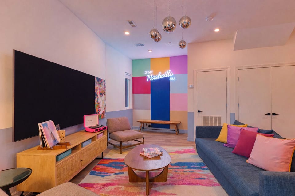 Living room with flat-screen TV and colorful design.