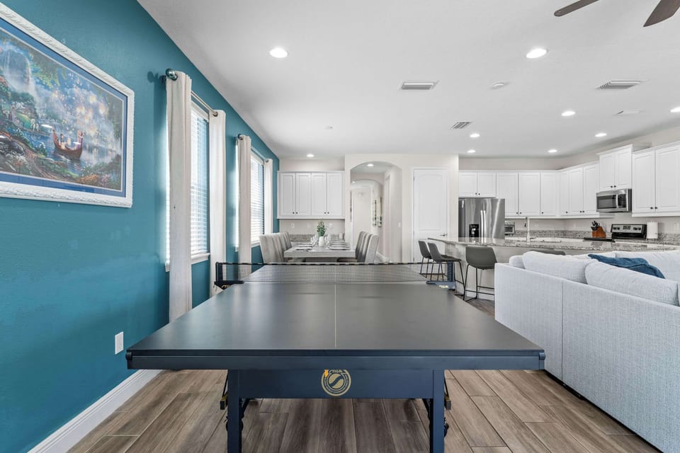 Bright open living area with Smart TV, ping pong table, and dart board
