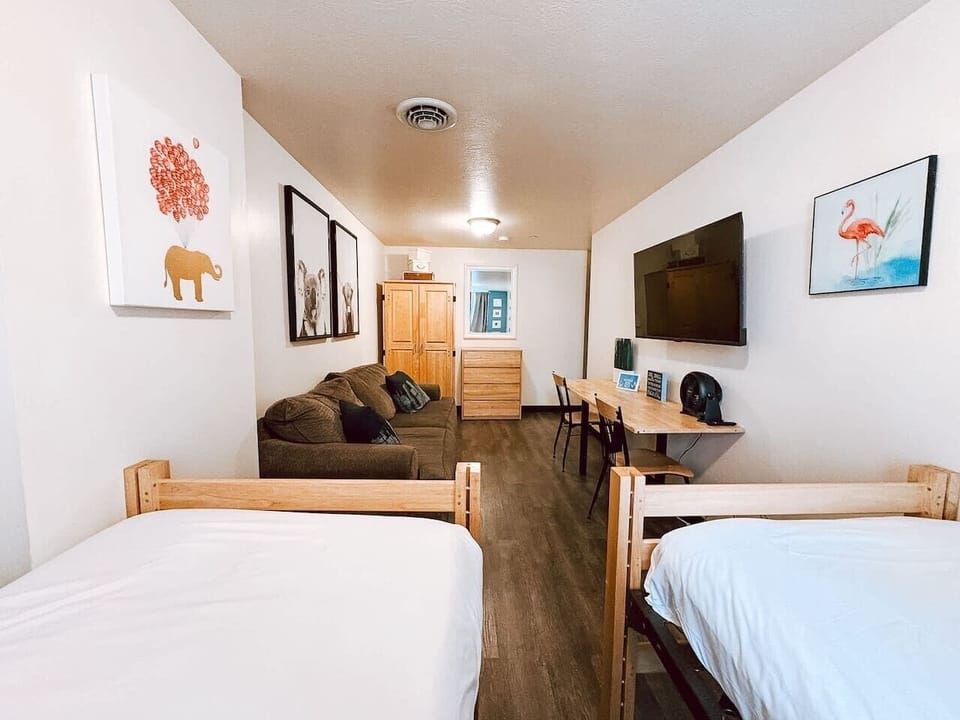 Bright sleeping area w/ twin beds, wardrobe storage & dresser space.