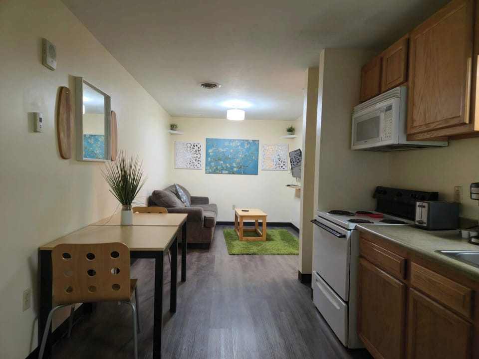 Open-concept design featuring kitchen, work desk, and cozy lounge area