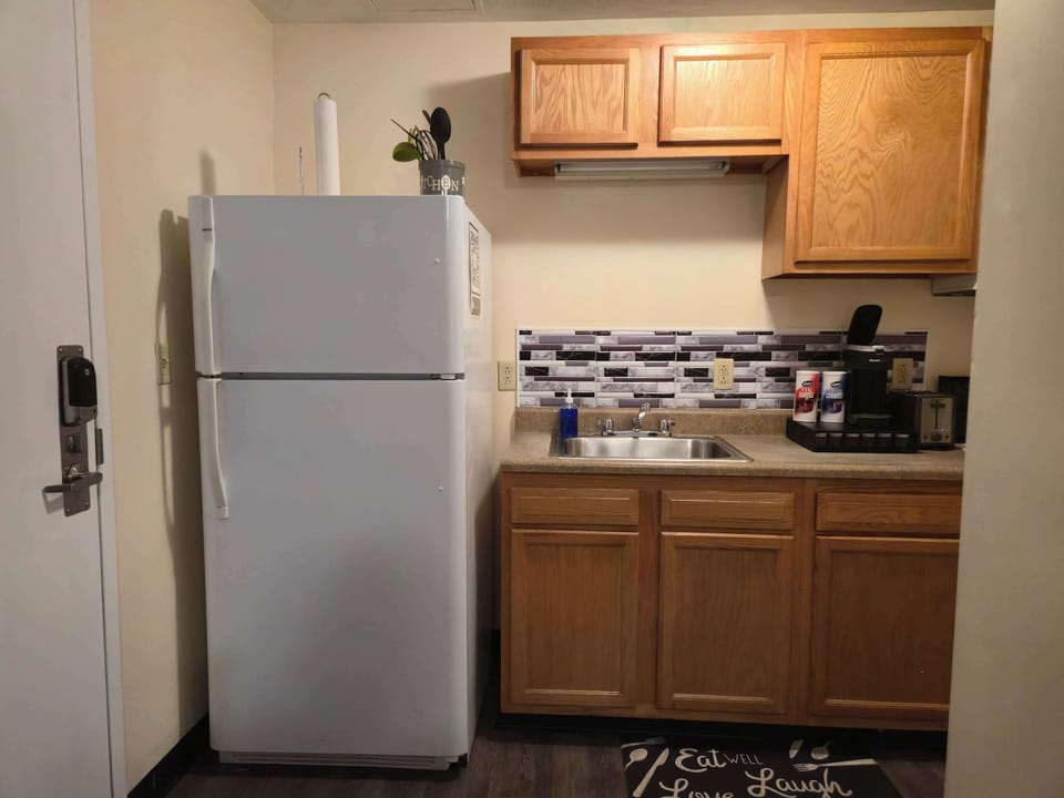 Kitchen equipped with refrigerator, sink, coffee maker and basic utensils, ideal for short or long stays.