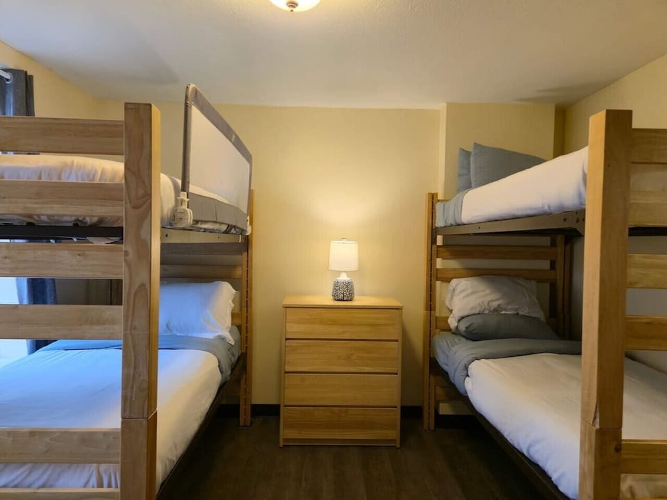 Large bunk bed room with cozy sleeping arrangements and convenient bedside storage.