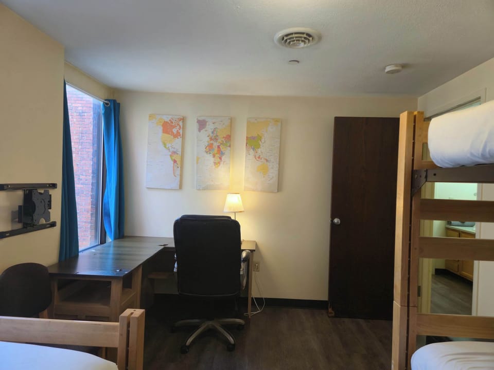 Work-ready corner with large desk, map décor, and natural light