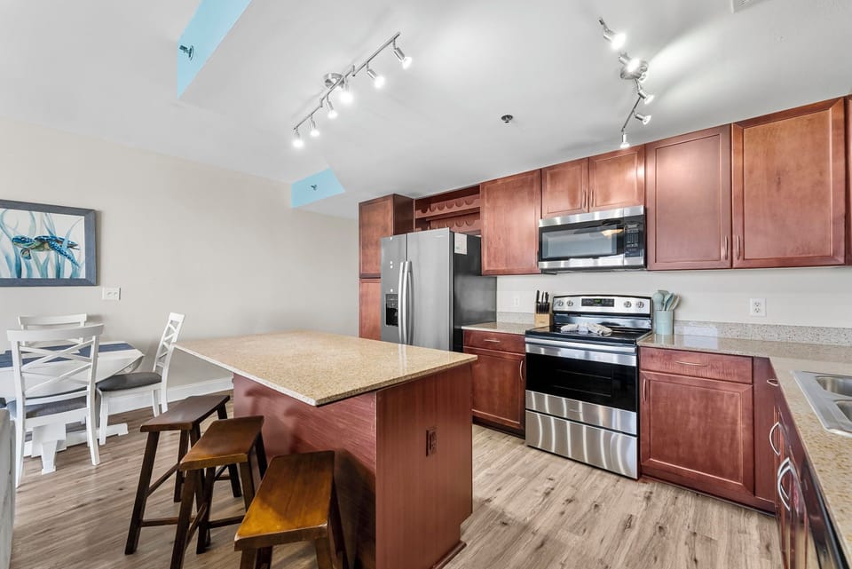 Modern kitchen with stainless steel appliances and a central island for casual dining.