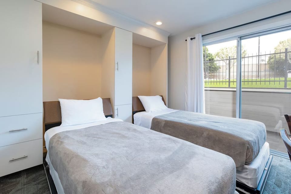 Wake up to daylight beside twin beds near sliding glass doors