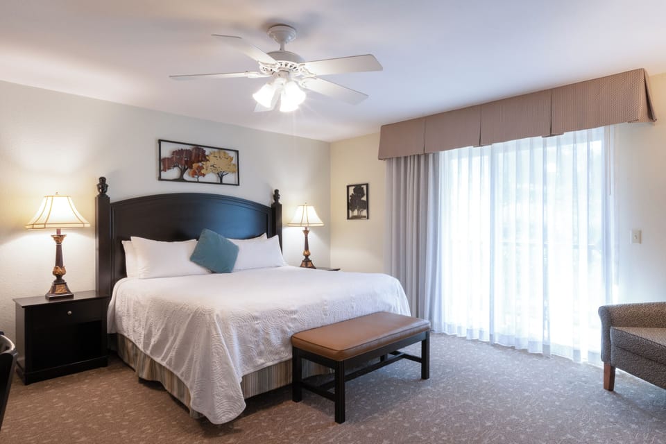 Unwind in a bright king bedroom with soft, airy drapes.