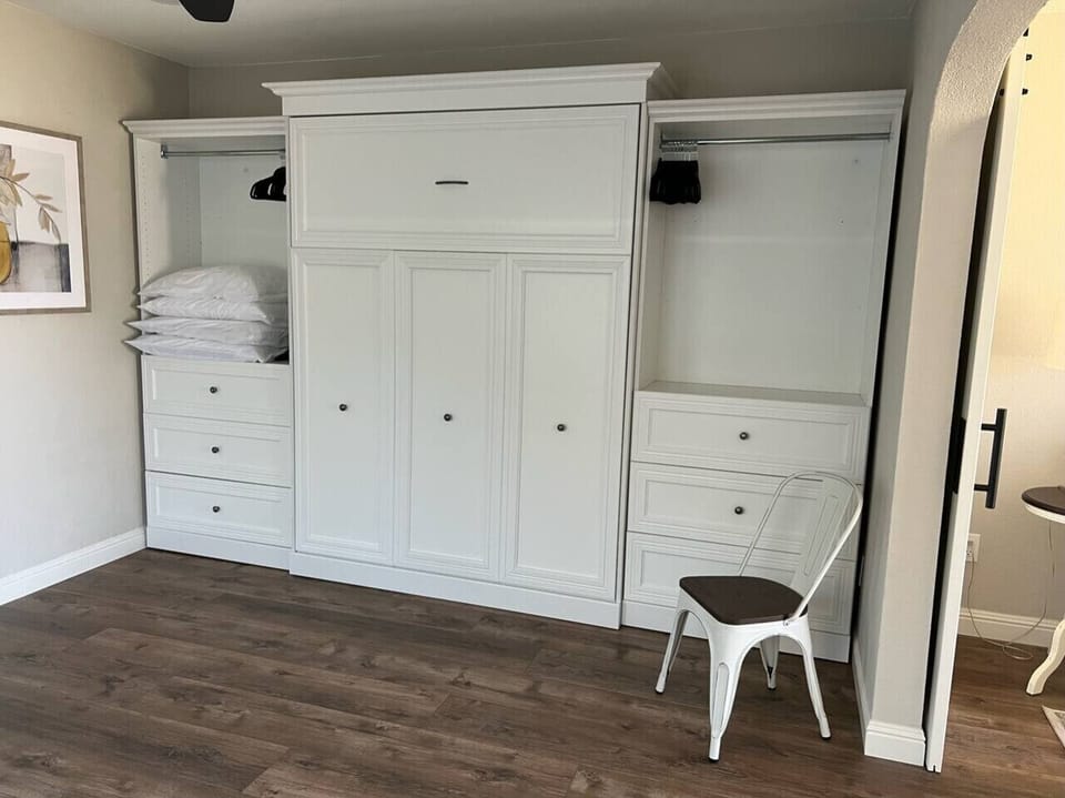 The murphy bed can be closed to make additional living space, and there is plenty of space to store clothing and personal items on either side of the bed.