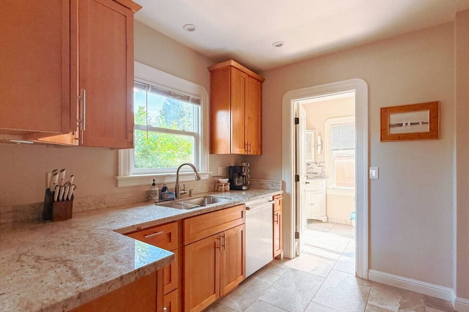 Bright, fully-equipped kitchen with everything you need - including a dishwasher and coffee machine for added convenience. The bathroom is located just steps away for easy access during your stay.