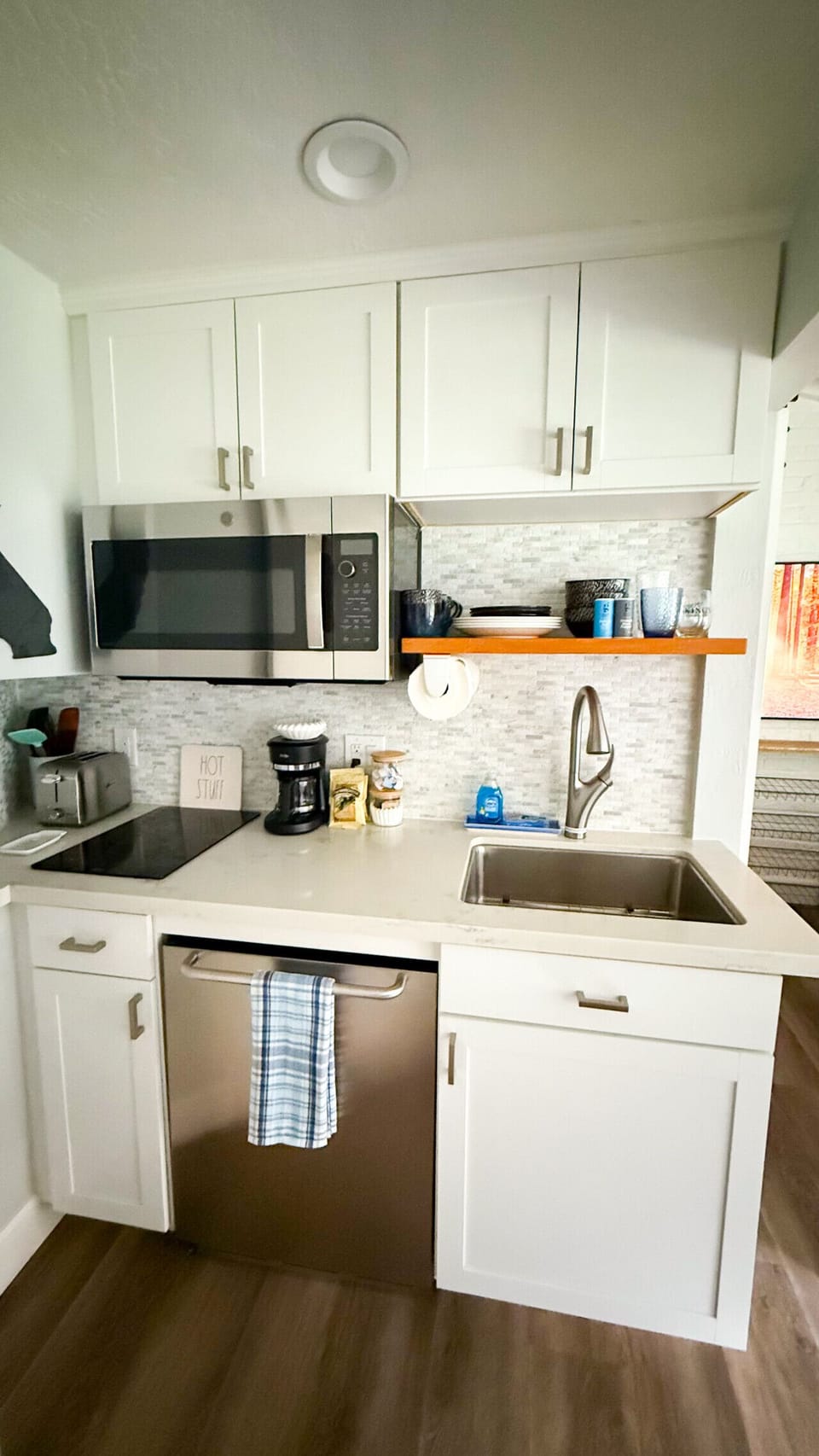The kitchenette includes an induction cooktop, small fridge, sink, microwave, toaster, coffee pot, and all the essential items you`ll need to get started.