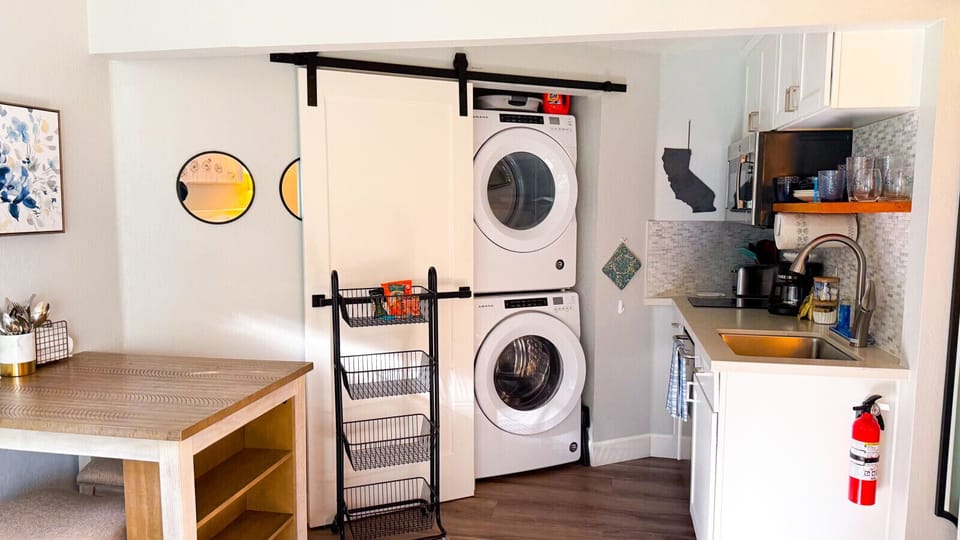 The studio has an in-unit washer and dryer that is located just behind an elegant yet functional sliding barn door