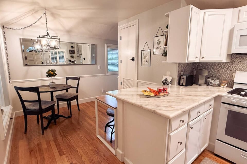 A dining table with seating for 2 is located just off the kitchen, and additional barstool seating is available at the kitchen counter.