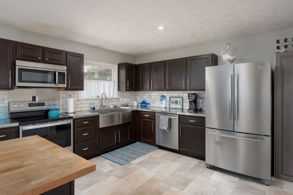 Your fully equipped kitchen awaits with sleek stainless appliances and rich dark cabinetry, ready for memorable meal prep.