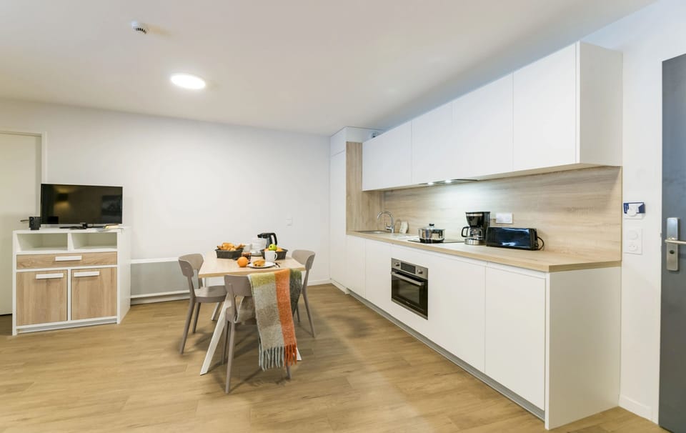 Enjoy shared meals in the dining area bathed in natural light, perfect for planning your next outdoor adventure in the Pyrenees.