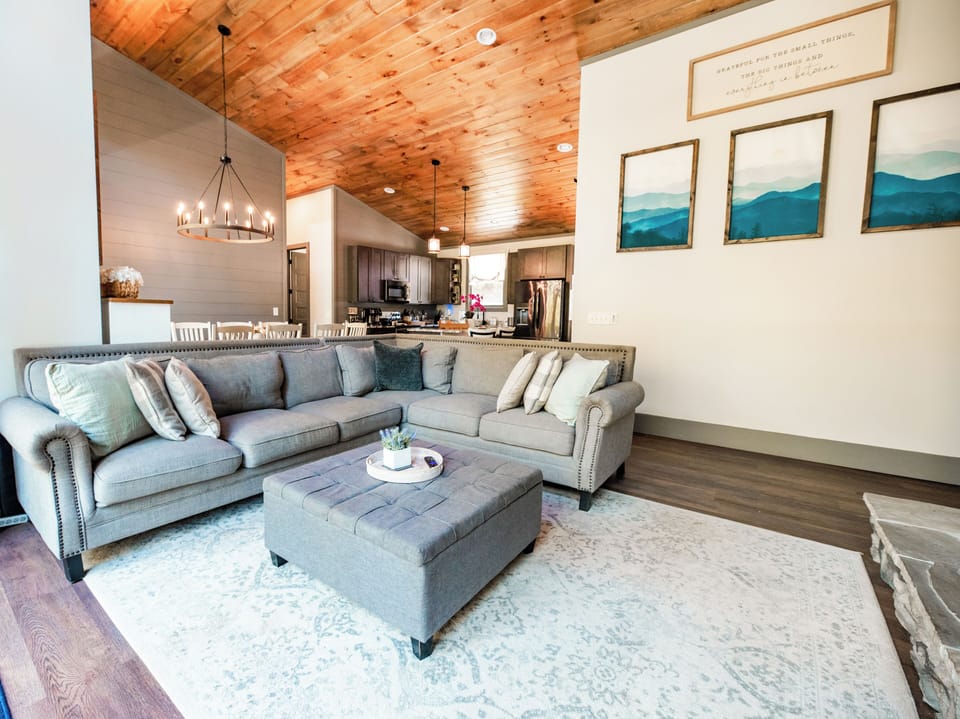 Cozy open-concept living room with vaulted wood ceilings and stylish decor