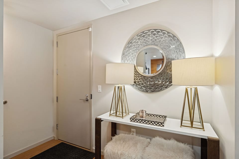 Stylish entryway with round mirror, console table, and neutral décor