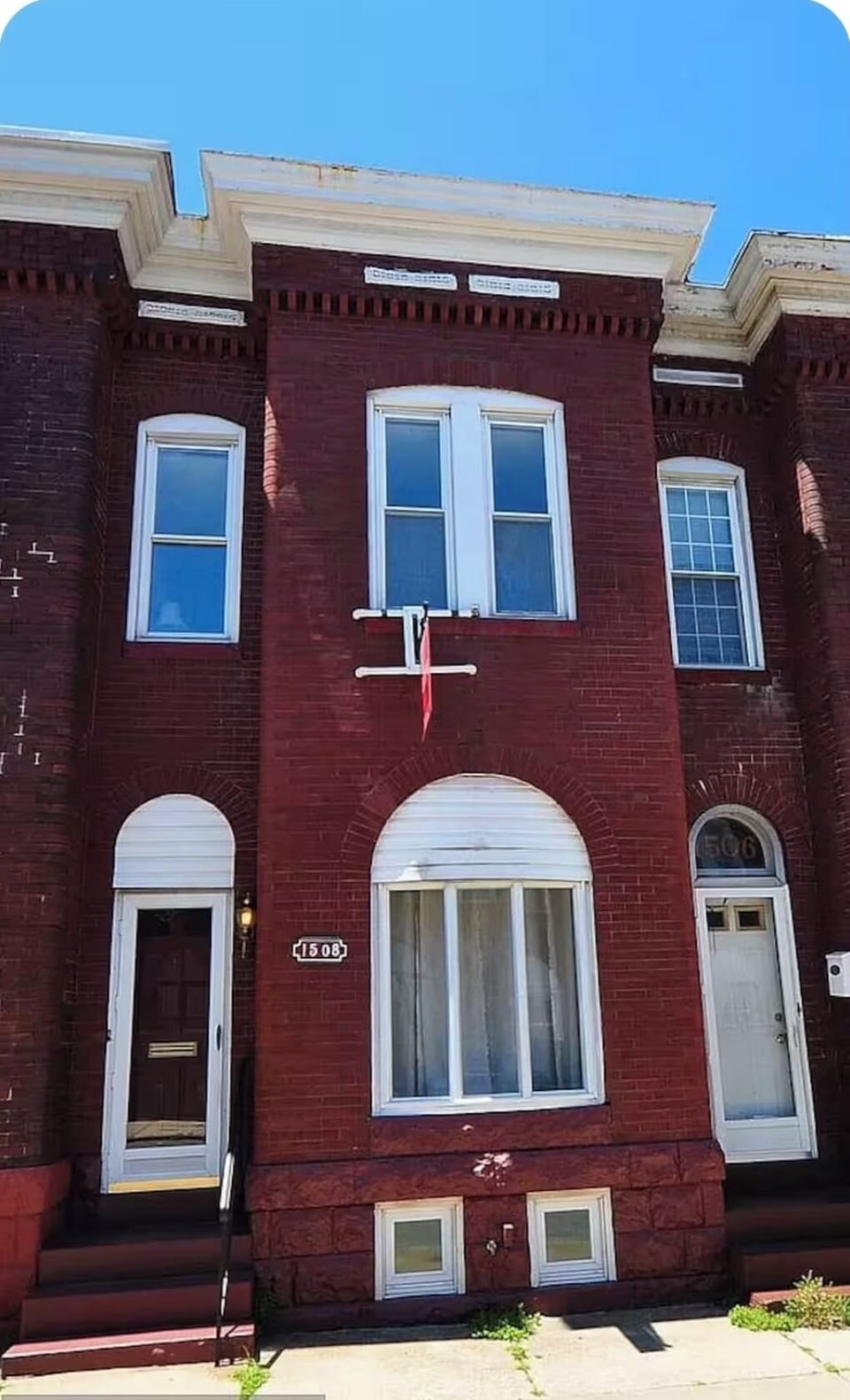 Front of the house. Currently, there is a black bench.
