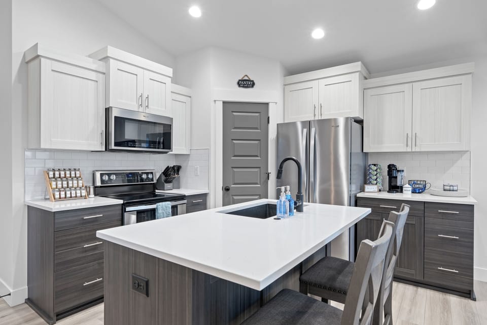 Another view of the kitchen with appliances and island with sink