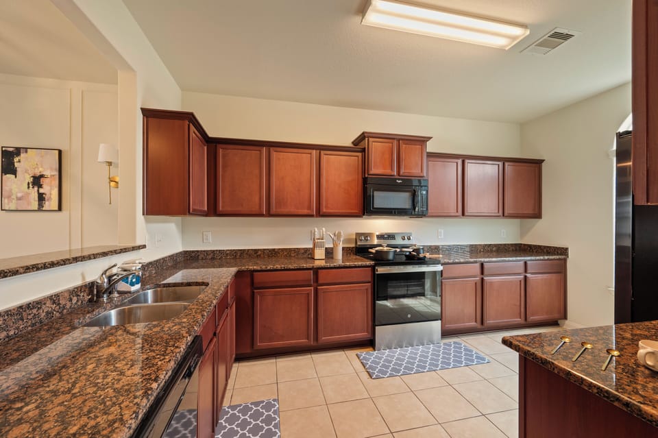 Fully equipped kitchen with air fryer, stove, fridge, and dishwasher
