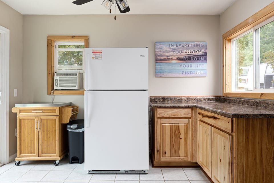 Well-equipped kitchen w/ full-size fridge, ample counter space & bright window views