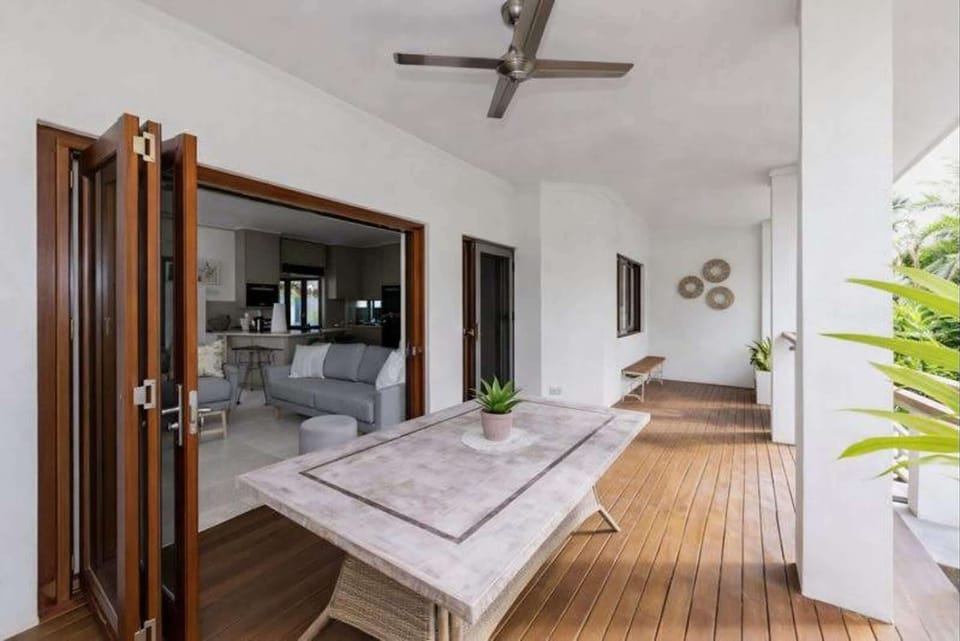 Indoor–outdoor living with large sliding doors and tropical outlook.
