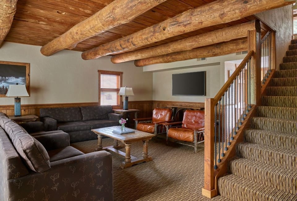 Spacious living space with rustic beams and cozy seating, perfect for relaxing after a day of exploring.