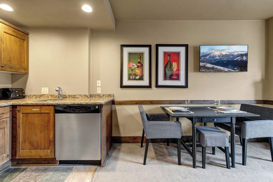 Your cozy open-concept space combines a fully equipped kitchen with warm wood cabinets and a stylish dining area.