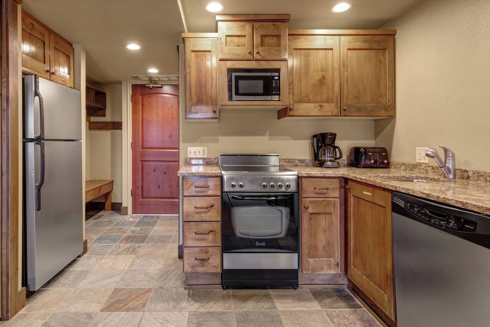 Your modern mountain retreat features a fully equipped kitchen with granite counters and stainless steel appliances.