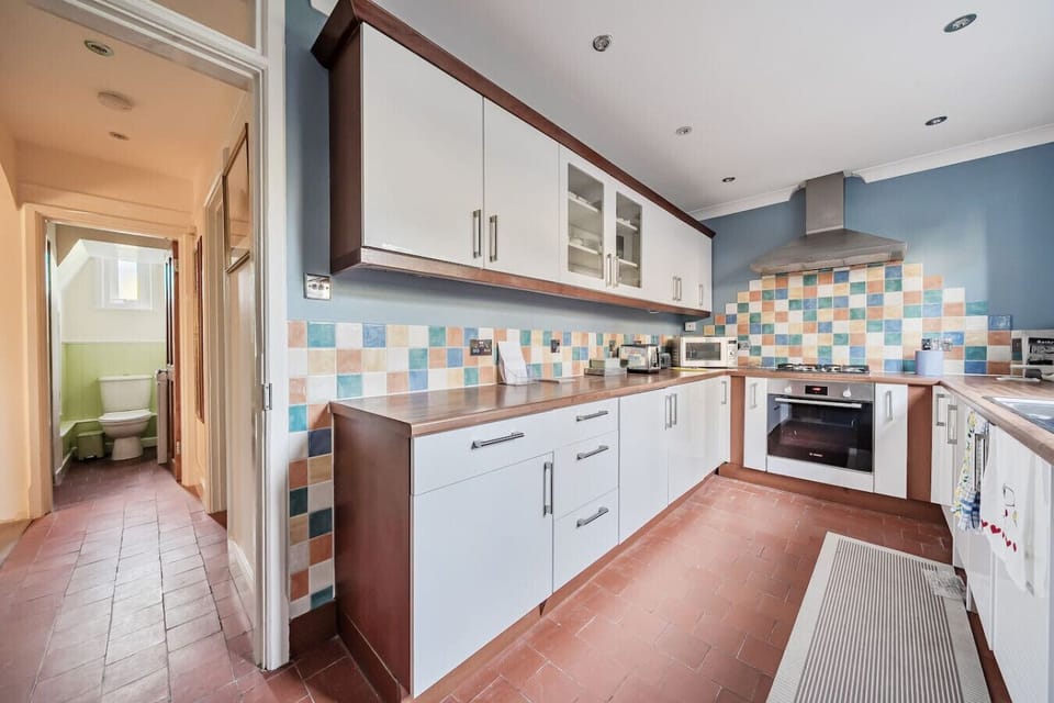 Colourful tiled kitchen with all essentials for cooking