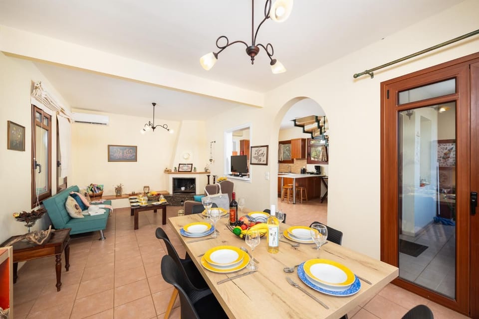 Living room with sofa, dining area, ornamental fireplace, A/C, WiFi internet, and satellite TV