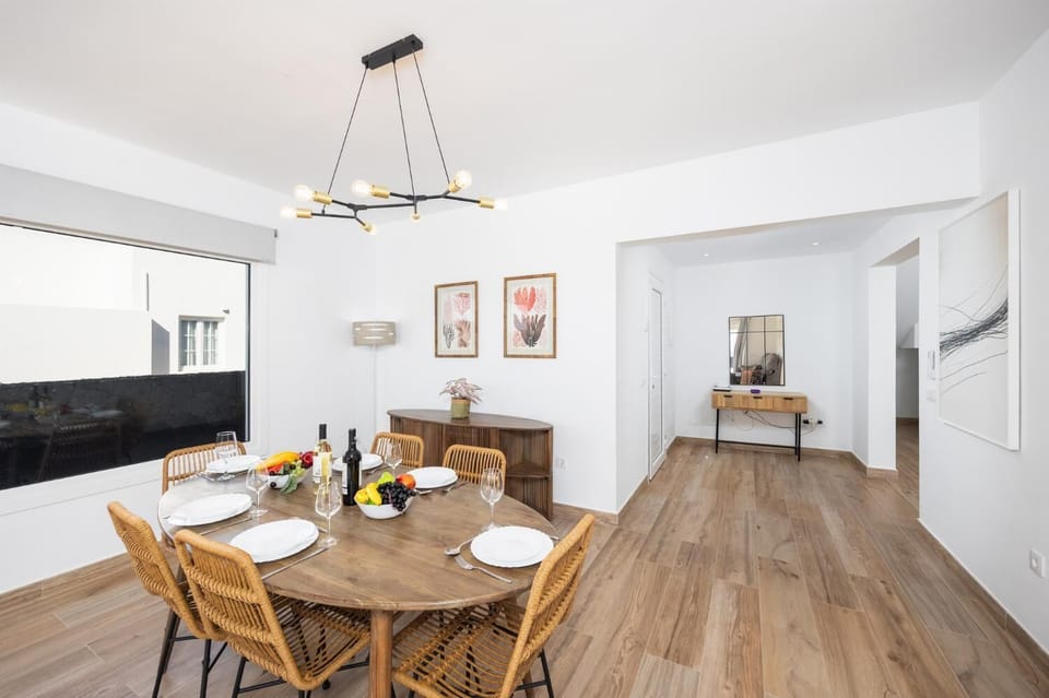 Open-plan living room with sofa, dining area, kitchen, A/C, WiFi internet, and satellite TV