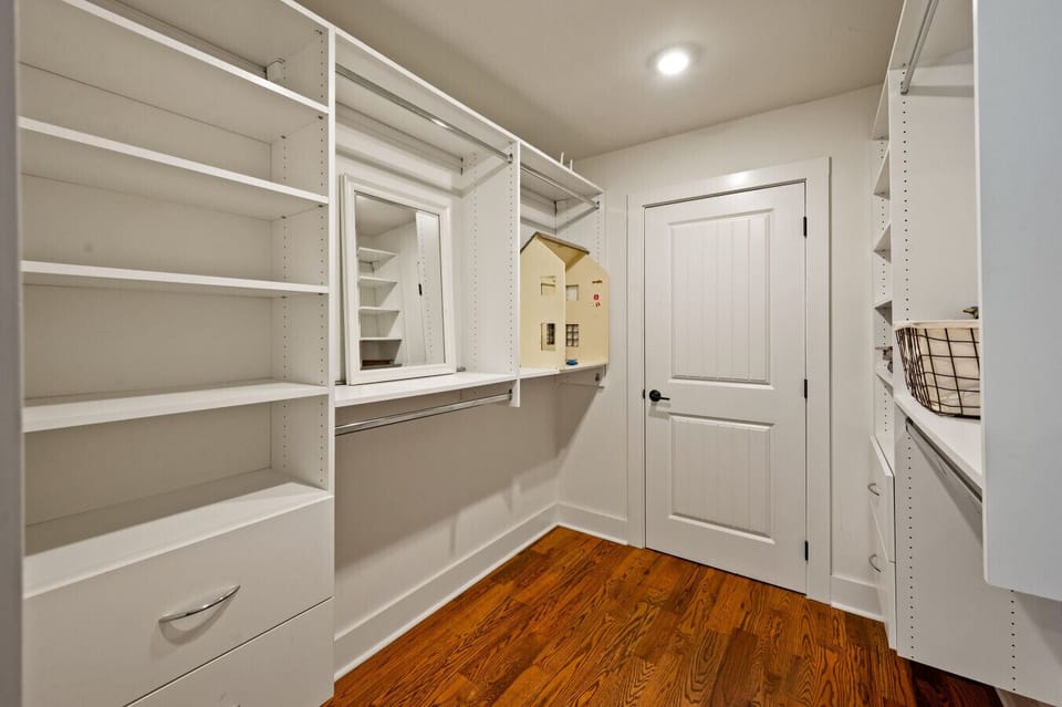 Walk-In Closet | Custom White Shelving & Storage | Built-In Mirror & Ample Hanging Space | Organized & Spacious Design