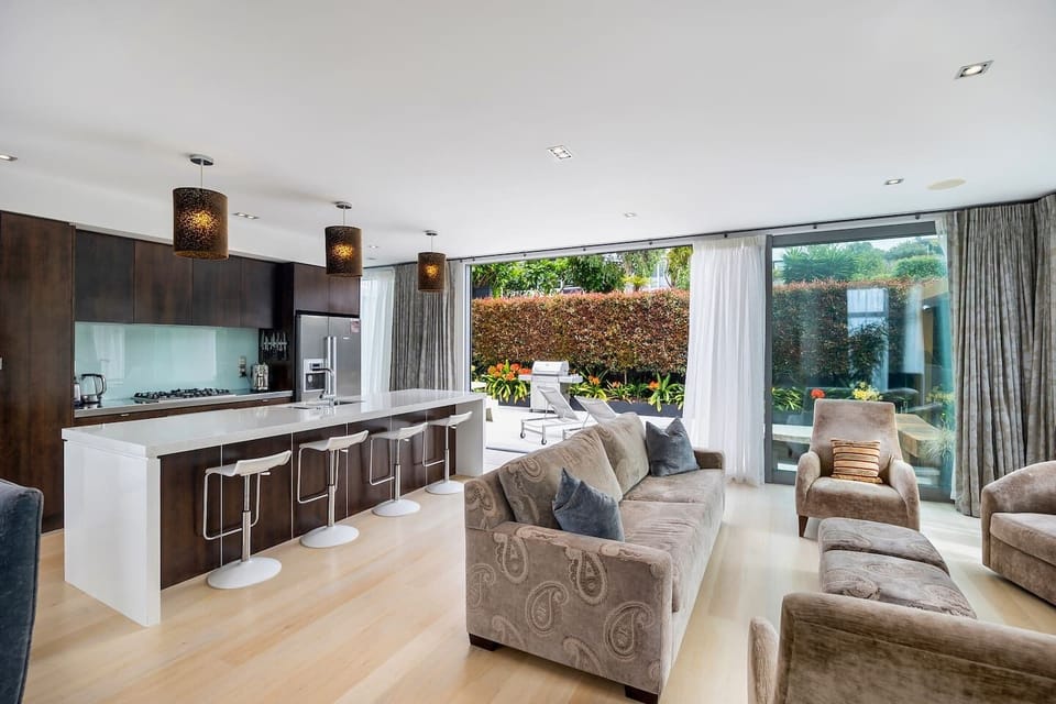Fully equipped kitchen and open plan living, with sliding doors leading out to a sunny terrace with BBQ and sun loungers