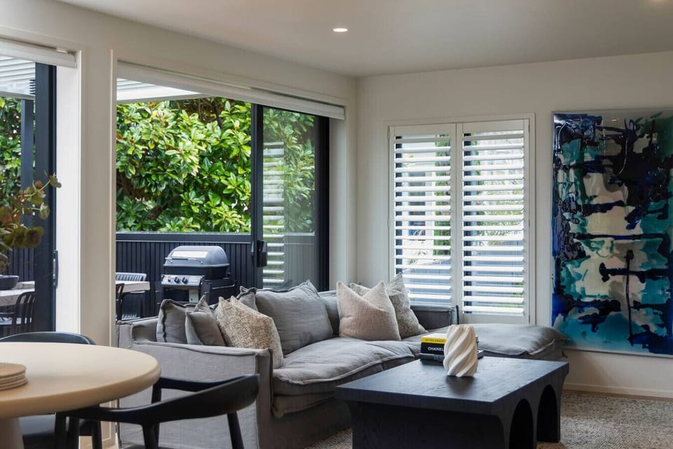 Modern spacious open plan living and dining, leading out to the sunny covered deck with additional dining and BBQ