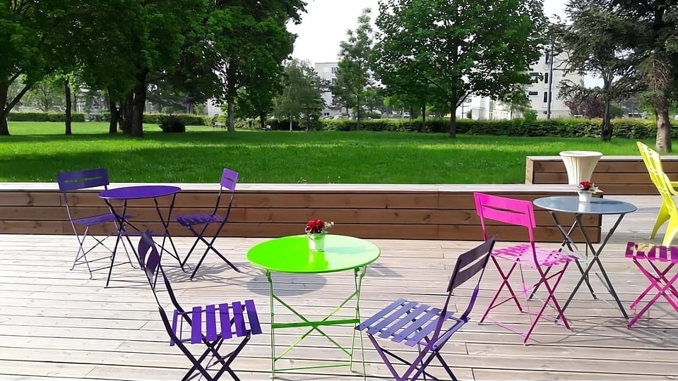 Sip coffee on the sunny terrace with vibrant seating.