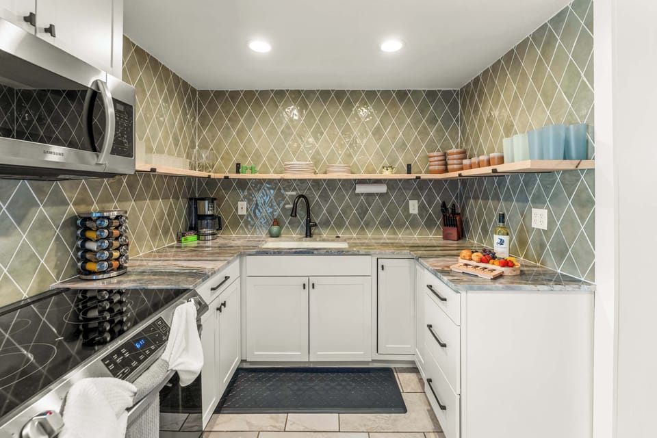 Fully stocked kitchen, with drip coffee maker (complimentary ground coffee, sugar and tea), cookware, dinnerware, and spices. Guests supply their own condiments.