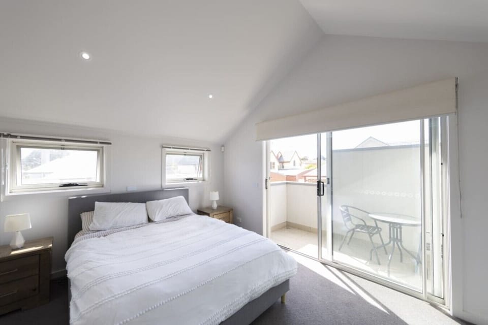 Light-filled bedroom with comfortable bedding and private balcony access.